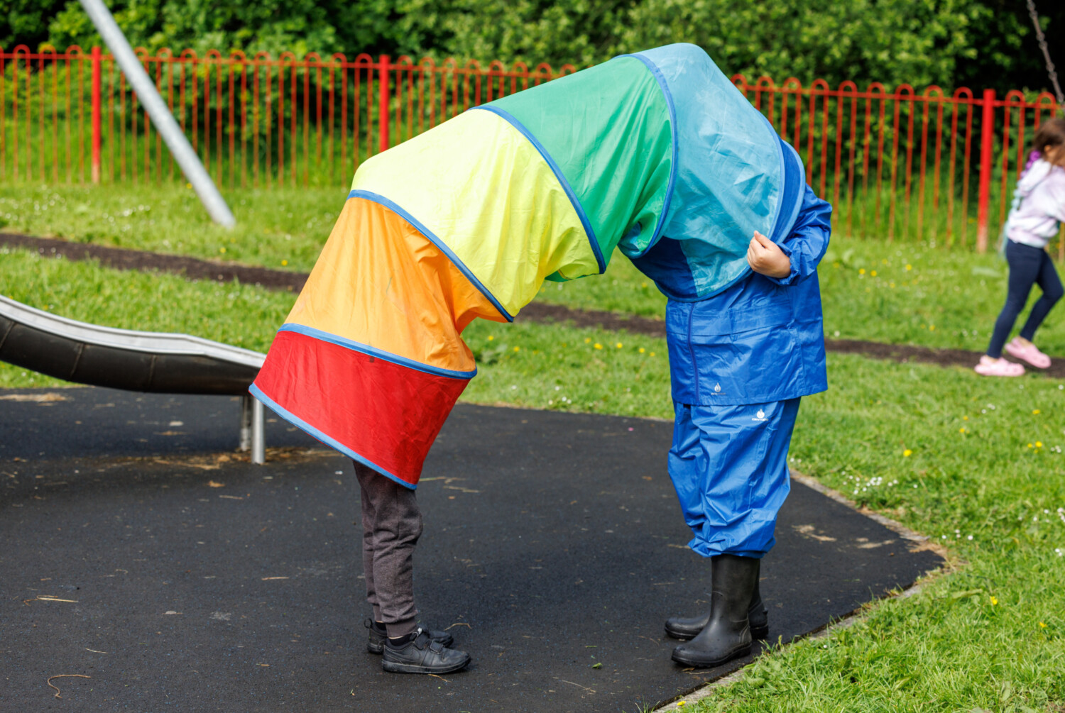 Two children playing in a colourful play tunnel