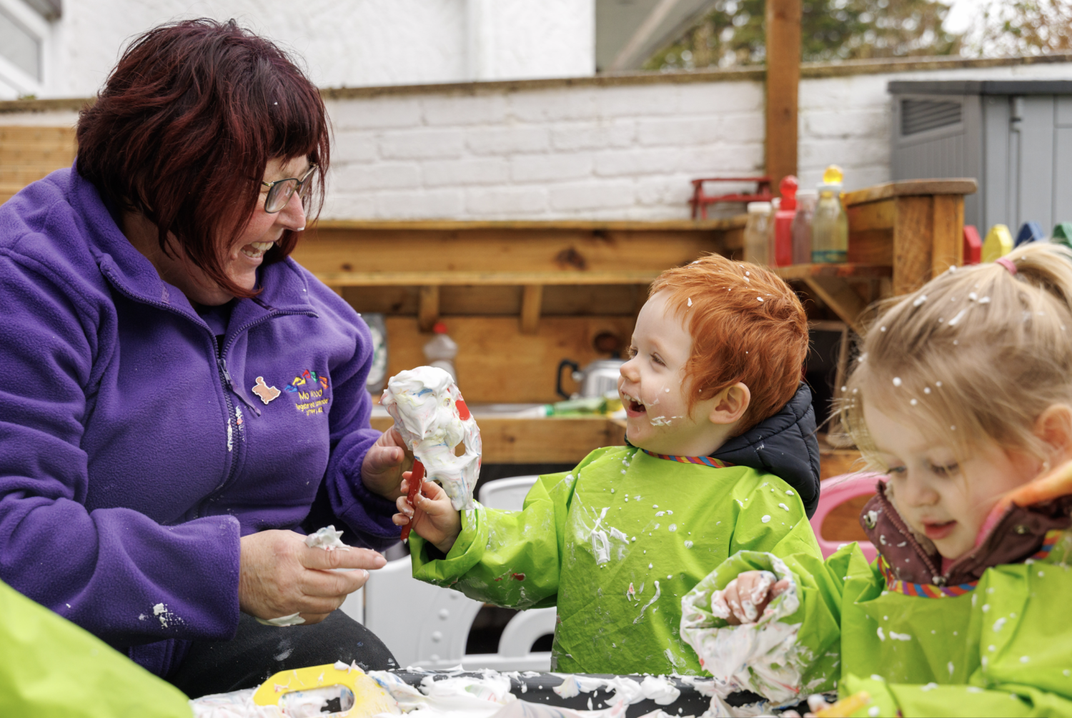 Childminder Mo playing outdoors with two children