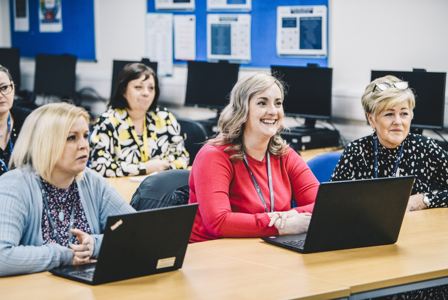 Students in a classroom environment with laptops on their desks